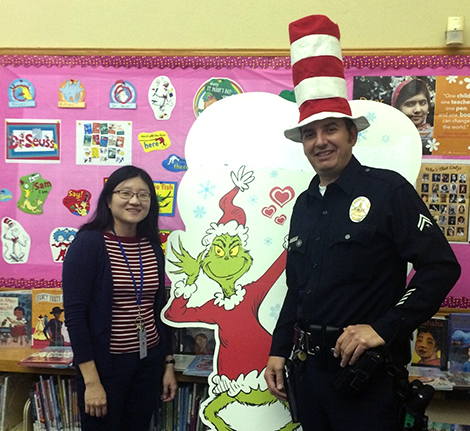 Officer Joseph Oseguera with a librarian wearing a silly hat