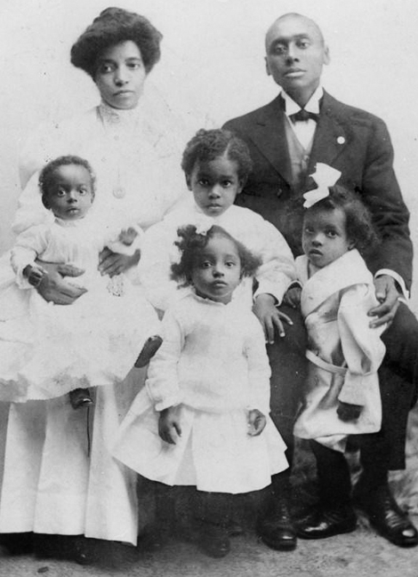 Amanda and Joseph pose with their children Grace, Raymond, Mildred, and Alphonso for a formal family portrait taken in 1907