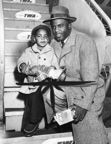 Dodger infielder Jackie Robinson and his son by TWA airplane stairs