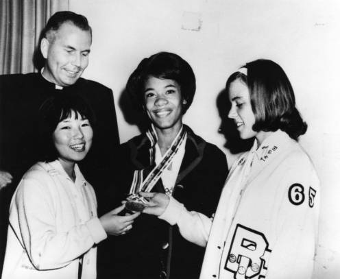 Marilyn White, the silver medal winner in track and field at the 1964 Olympic Games, shows her medal to friends at Bishop Conaty-Our Lady of Loretto High School, her alma mater.