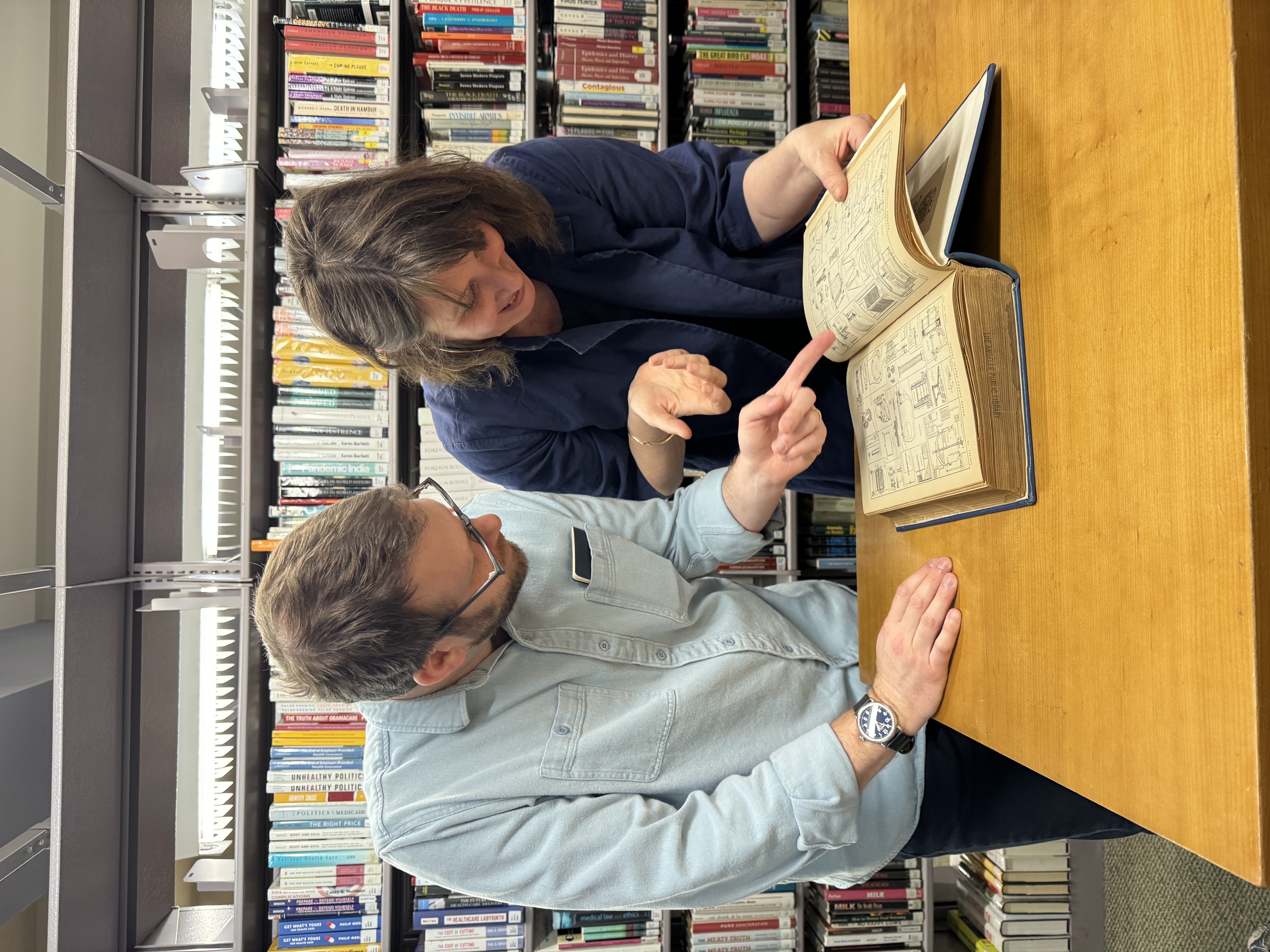 Ellen Harvey in the L.A. Central Library looking at Patent drawings with curator Todd Lerew