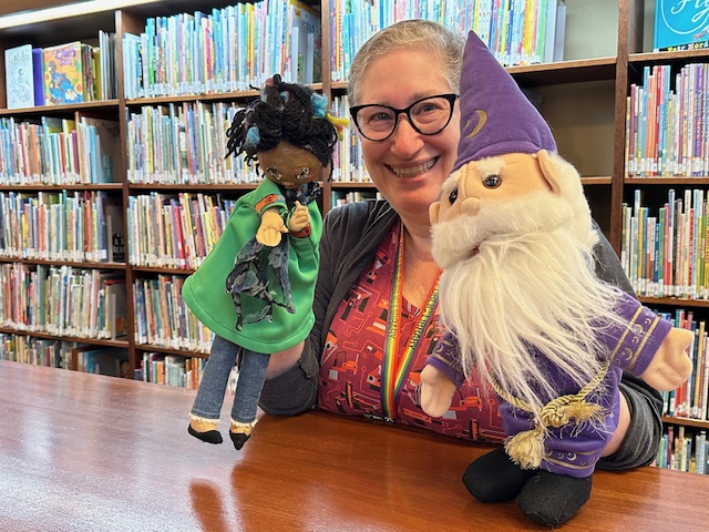 Mara holding the Wizard and Librarian puppets