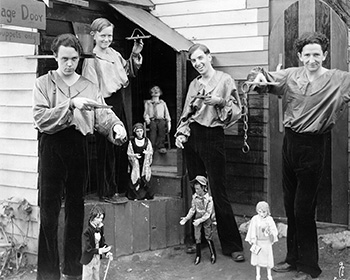 b/w photo of the Yale Puppeteers with their young neighbor Buster Jensen, puppets in hand, at their new home in the Hollywood Hills