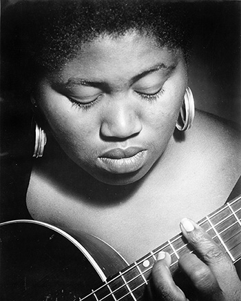b/w photo of Odetta, the famous 1960s folk singer, musician, and human rights activist,holding a string instrument