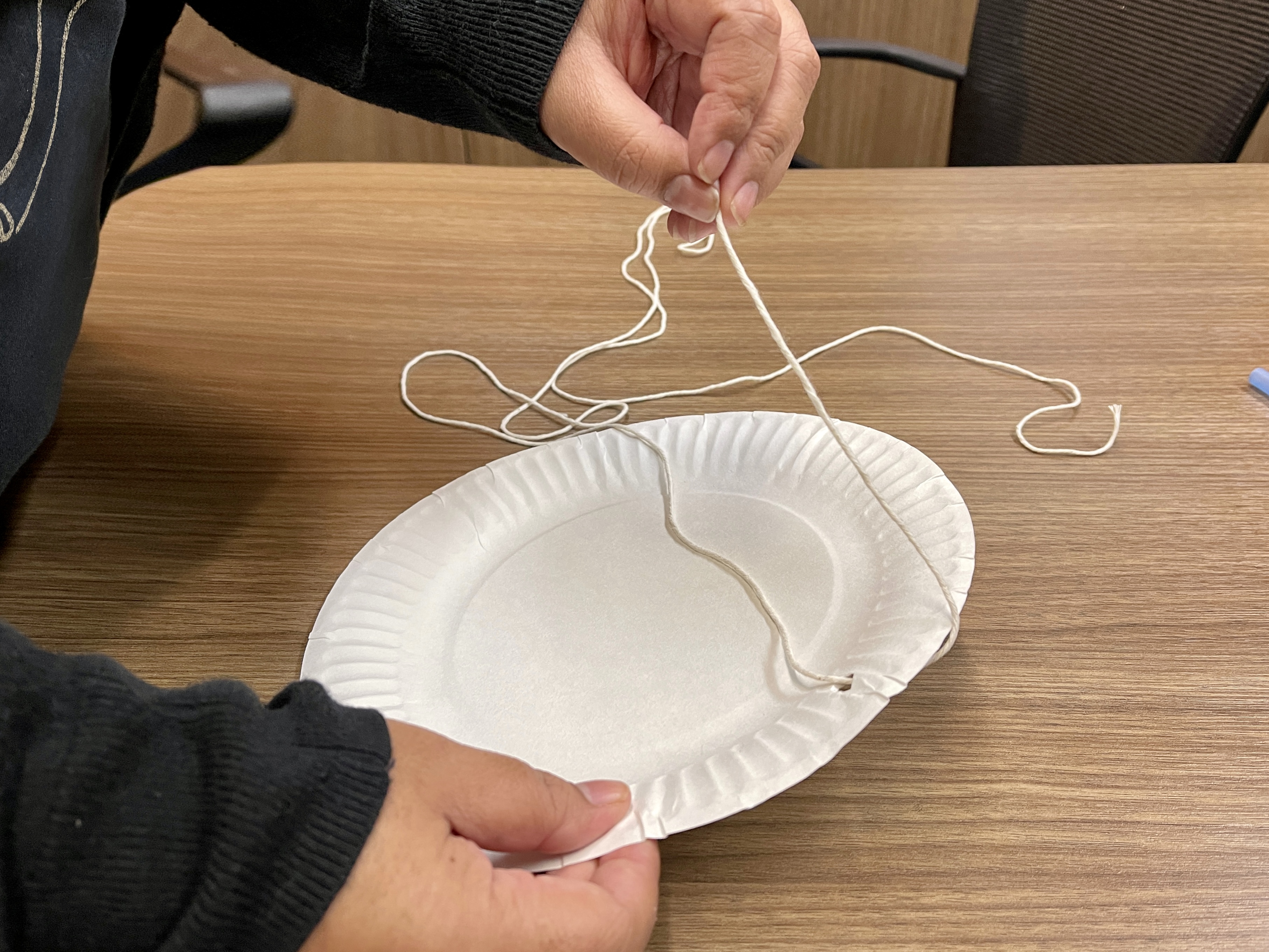 pulling a string through a paper plate