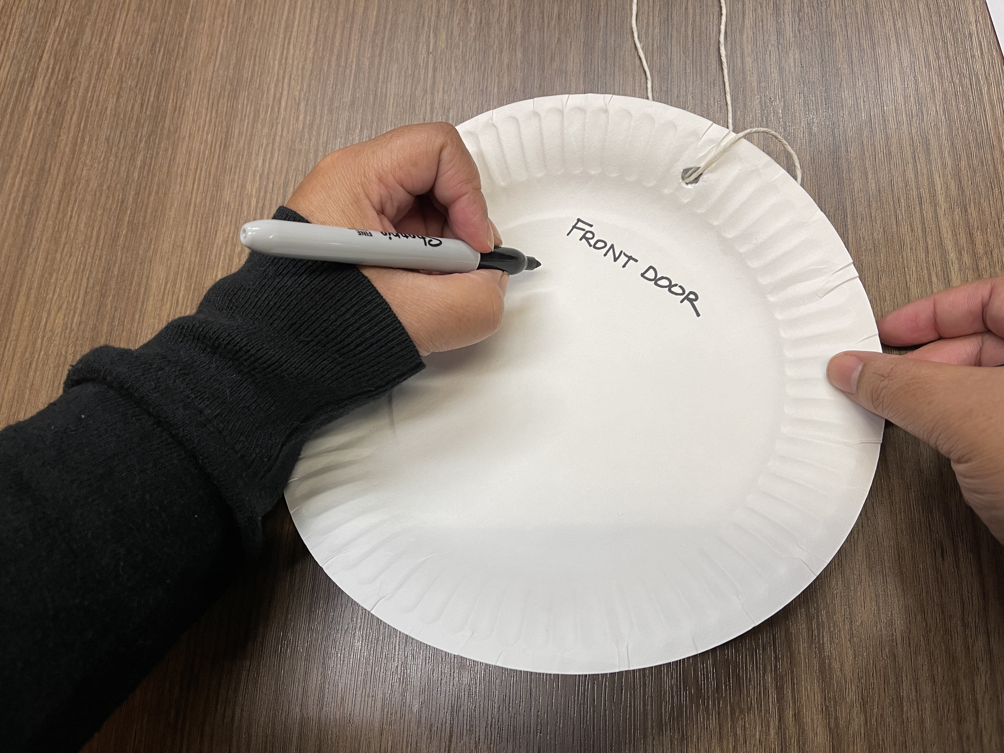 a person writing a location on a paper plate