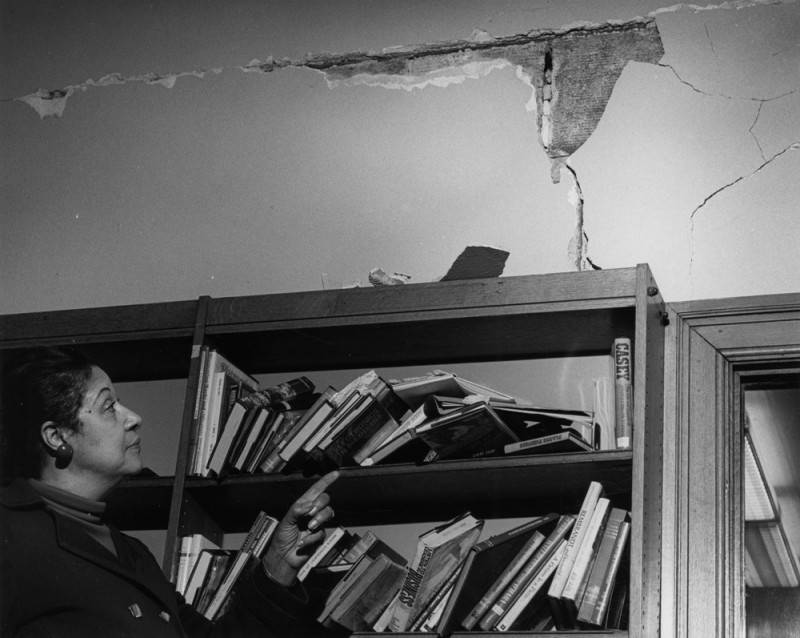 Commissioner King reviews earthquake damage at the Vernon Branch Commissioner King looks at crack in wall at Vernon Branch