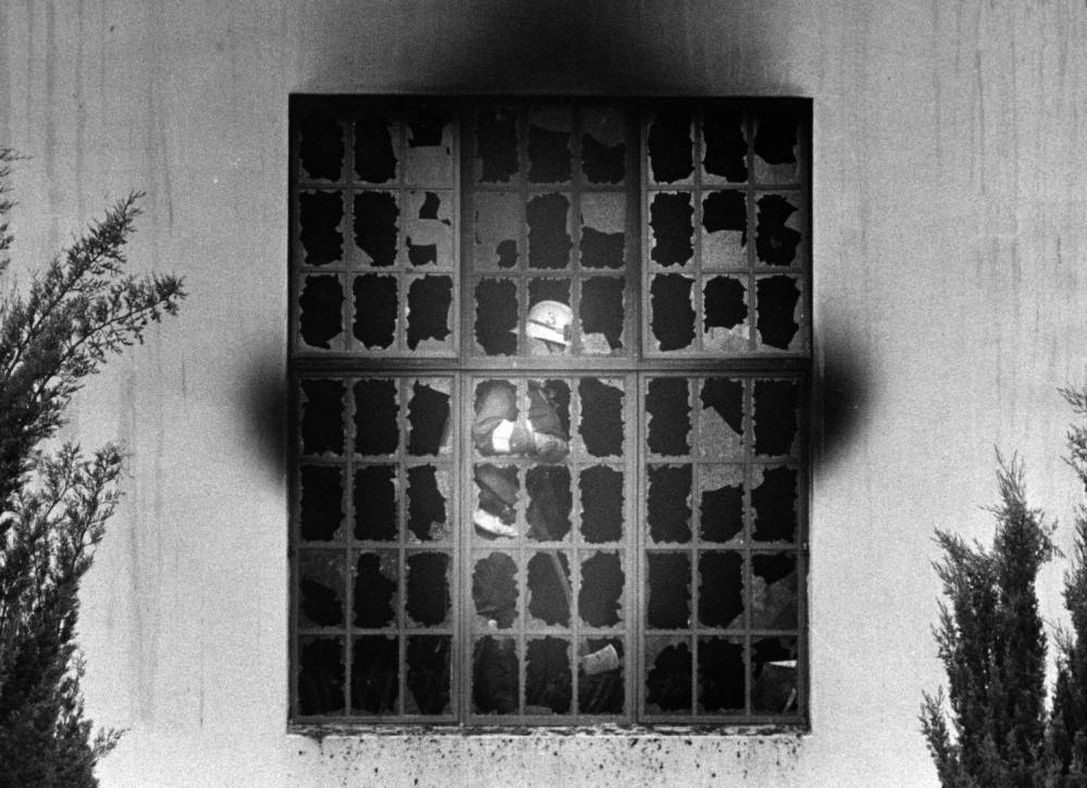 Firefighter behind broken window