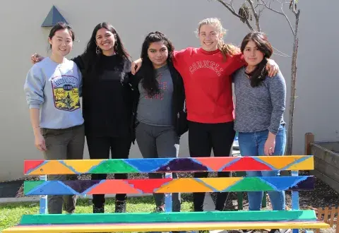group of teens with a painted bench