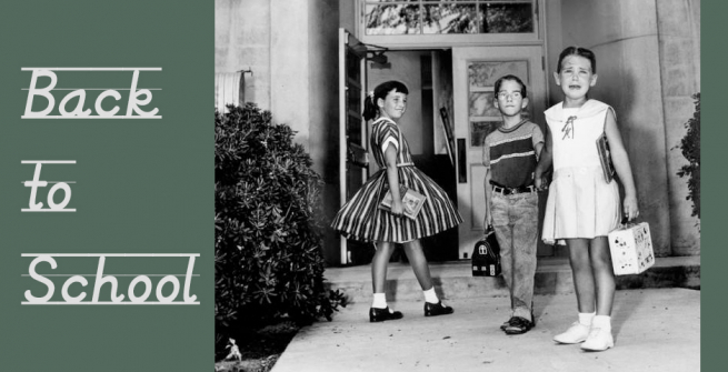 3 children heading into a school on the first day