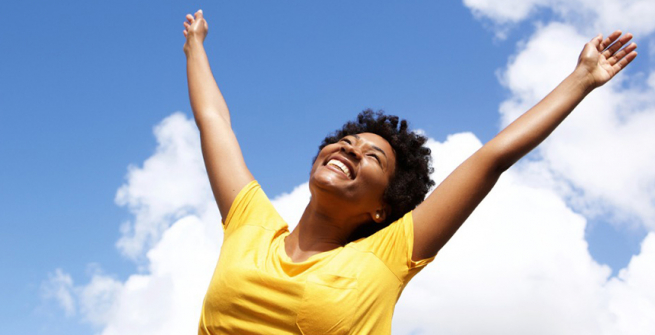 cheerful young woman with hands raised