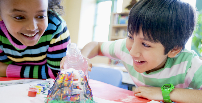 Happy kids working on a volcano experiment