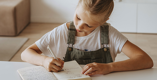 Young girl writing in her journal