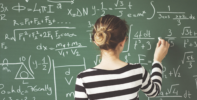 Girl solving a mathematical problem on the blackboard