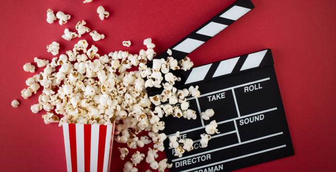 popcorn and film clapper on a red background