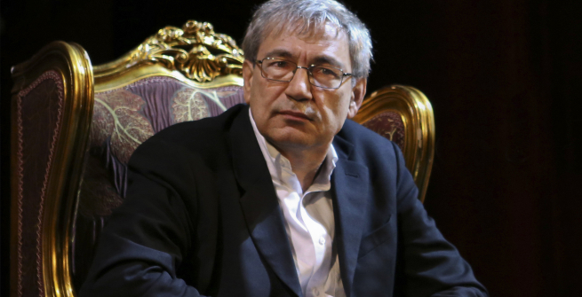 Orhan Pamuk sitting in a big gold chair