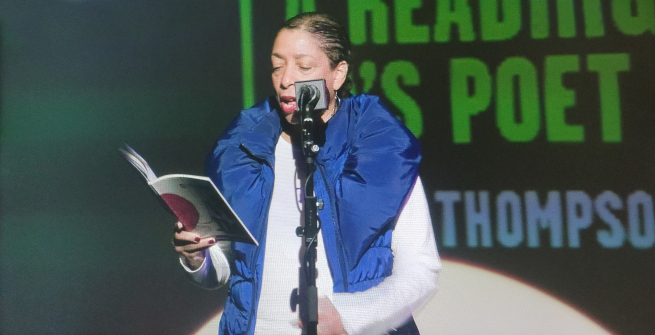 Lynne Thompson reading potery at an event