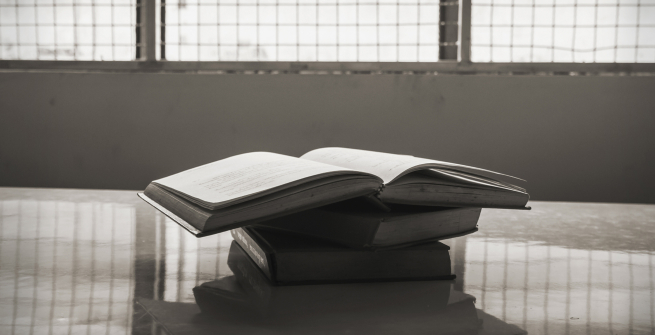 open stack of books on a table in prison
