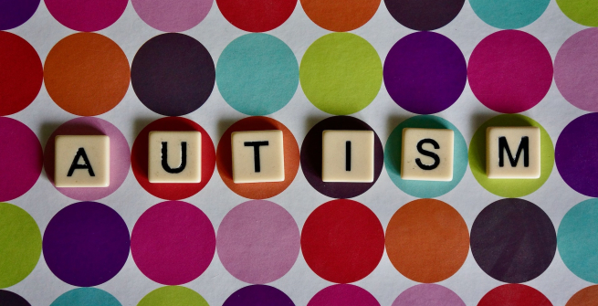 Scrabble tiles spelling out the word AUTISM