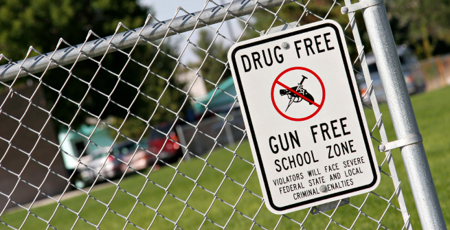 chainlink fence with a sign that reads drug free gun free school zone