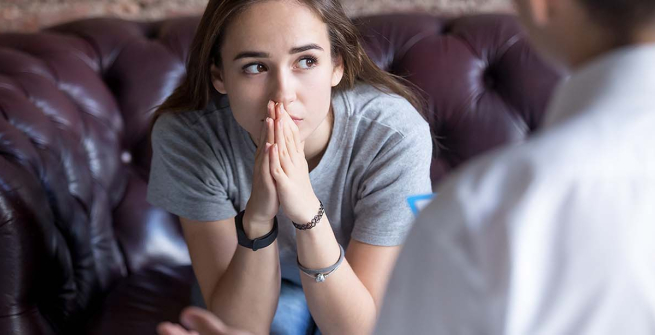 teen girl hands clasped looking up in thought