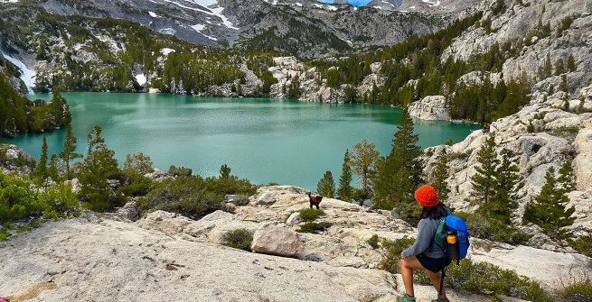 hiker looking at a vista with a lake and mountains