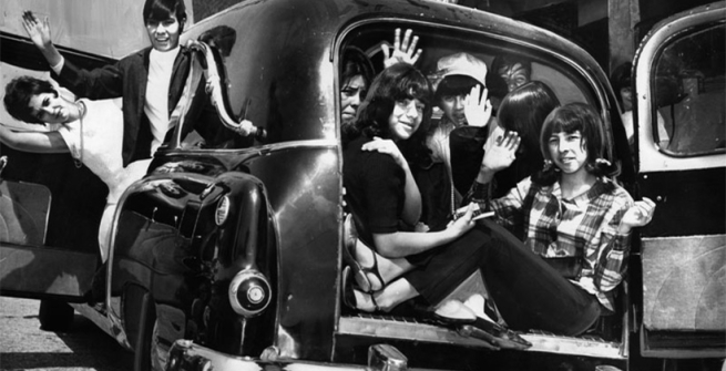 teenagers waving from inside a hearse