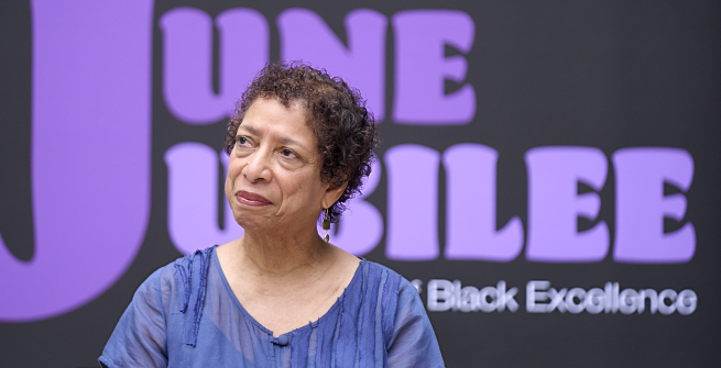 Poet Lynne Thompson in front of LAPL's June Jubilee banner