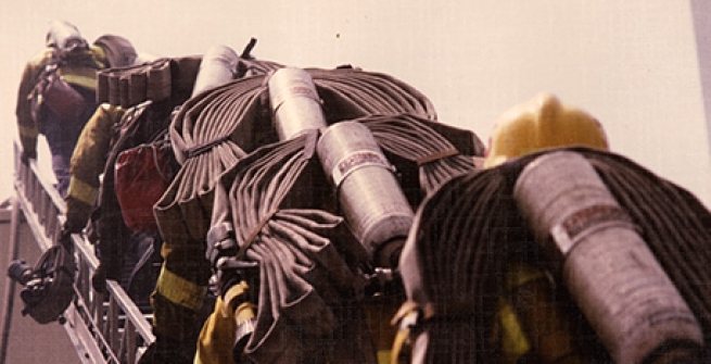 firefighters climbing ladder with equipment
