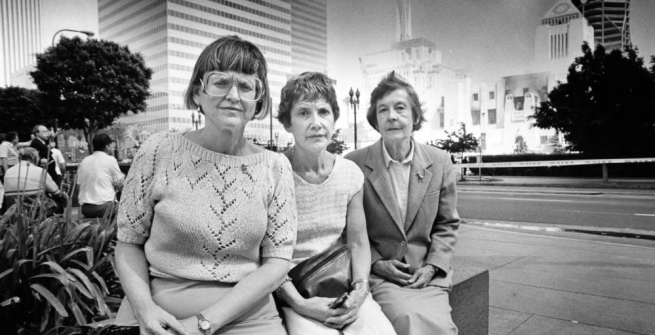 Three librarians are pictured in front of the burning Central Library 