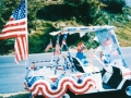 A boy drives a golf cart decorated for a Fourth of July parade in San Pedro.
