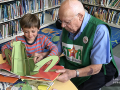Senior reading to a child at the library