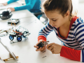 Young girl building an electronic device