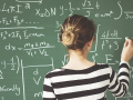 Girl solving a mathematical problem on the blackboard