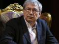 Orhan Pamuk sitting in a big gold chair