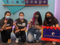 Teen’Scape sign with Michelle, Ashley, Julia, and a teen volunteer
