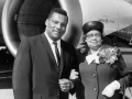 Photographer Rolland J. Curtis and his mother, Mathilda Curtis. They are standing near a Delta Airlines plane, and she is wearing a corsage.