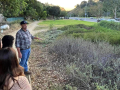 teens watching a gardner looking at native plants