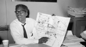 Bayard Rustin holding up a city map and pointing at it.