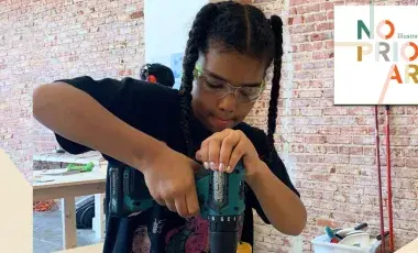child using a power tool to drill a piece of wood