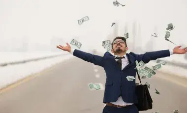 Young guy in a blue suit and white shirt, standing on a bridge, with arms spread wide throwing money into the air