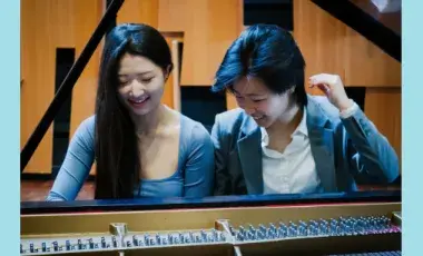 Musicians Rubi Choi and Claire Wang seated at a piano