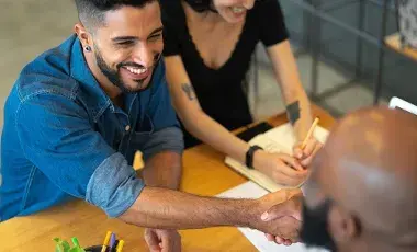 Two people shaking hands with another person