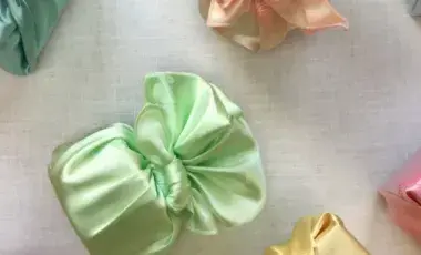 Examples of folded Bojagi cloth in the colors green and pink.