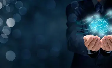 Two hands holding a floating holographic image of a brain