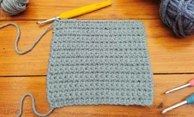 gray color knitting sample with knitting needles on the side