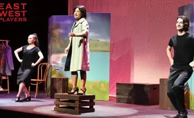 Three performers on stage acting