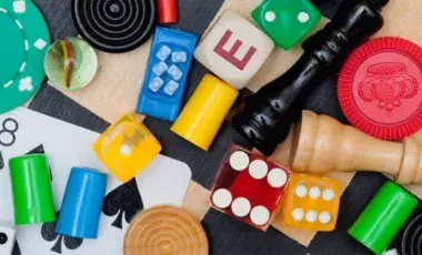 dice, checkers, chess, and other game pieces scattered on a chess board
