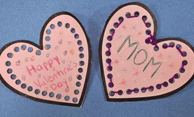 two pink hearts with mom and happy valentine's written on them. 
