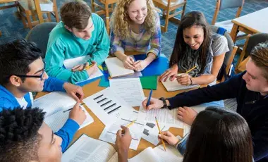 A group of students gather to study around a table